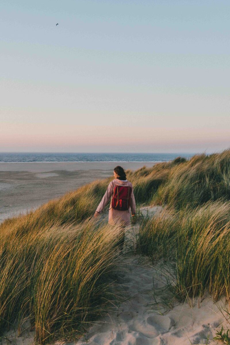 Vrouw loopt in de buurt van de zee bij zonsondergang Vrouw loopt in de buurt van de zee bij zonsondergang